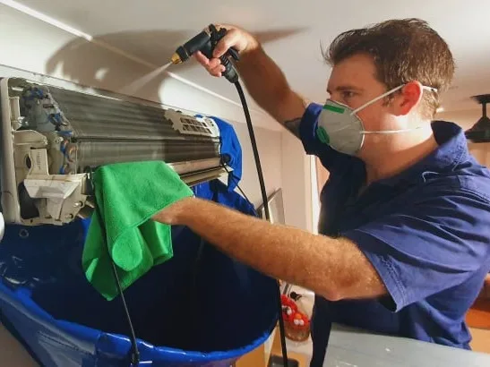 Spotless Aircon Cleaning 3 Technician performing air conditioner cleaning on a split system unit Sunshine Coast