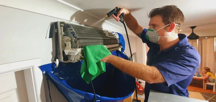 Technician cleaning a unit with drop sheet